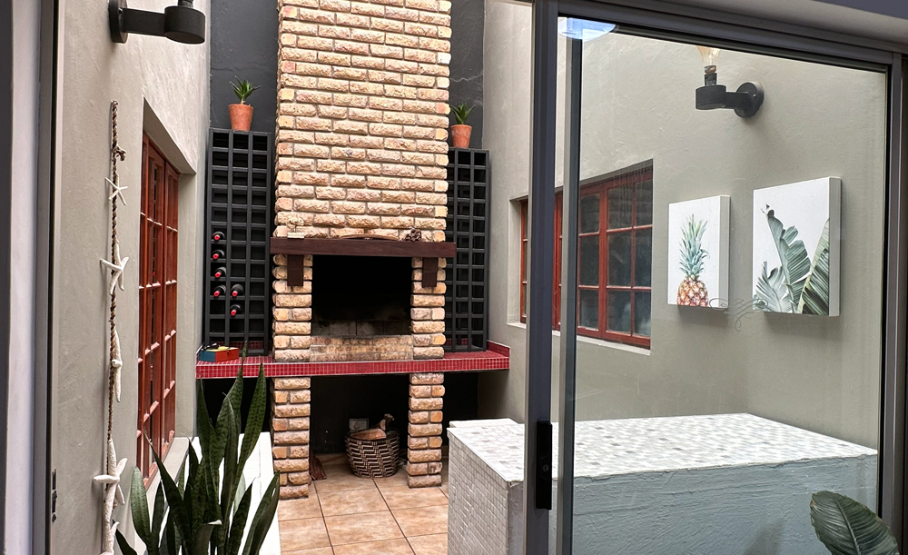 Entrance to the inside braai area with seating and mini-bar fridge.