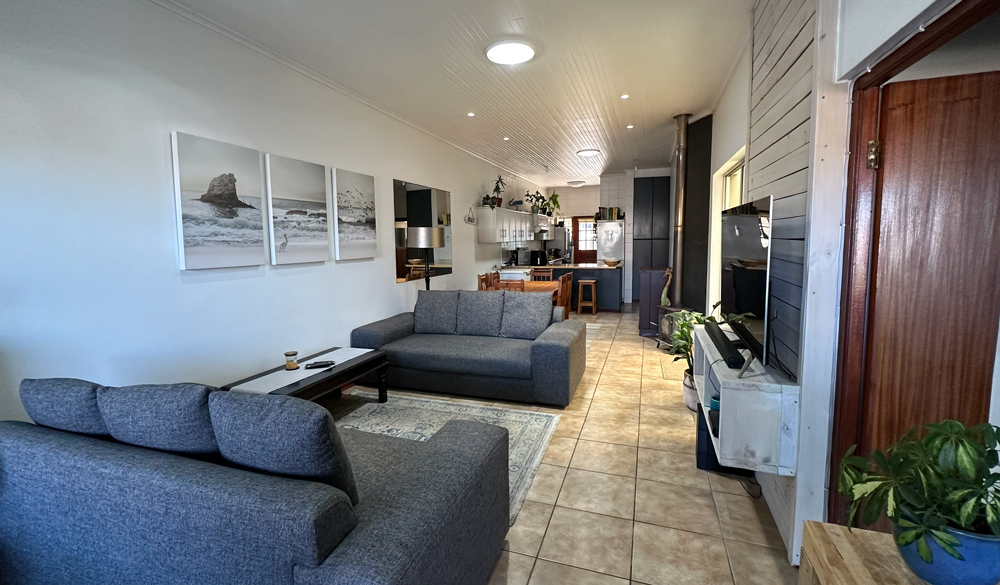 Lounge with 3-seater couches, 55" Smart TV and DStv decoder.